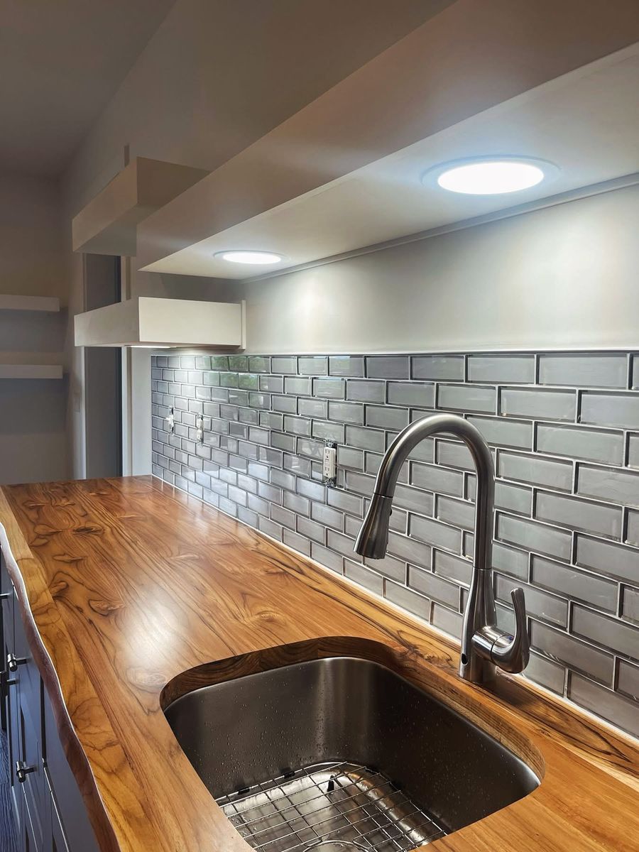 Kitchen remodel with grey subway tile backsplash, live-edge wood countertop, and undermount sink