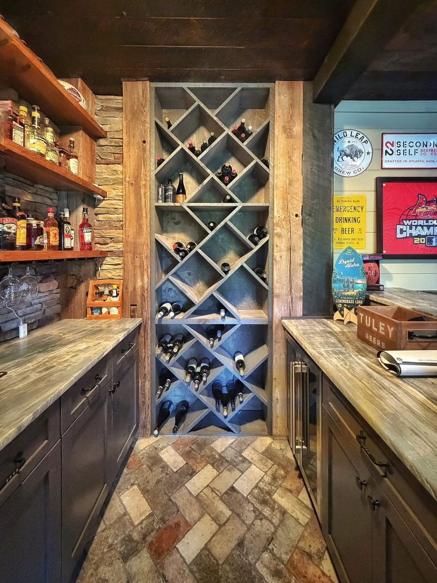 Custom diamond-pattern wine rack built into a stone-wall bar area with reclaimed wood trim and a herringbone brick floor